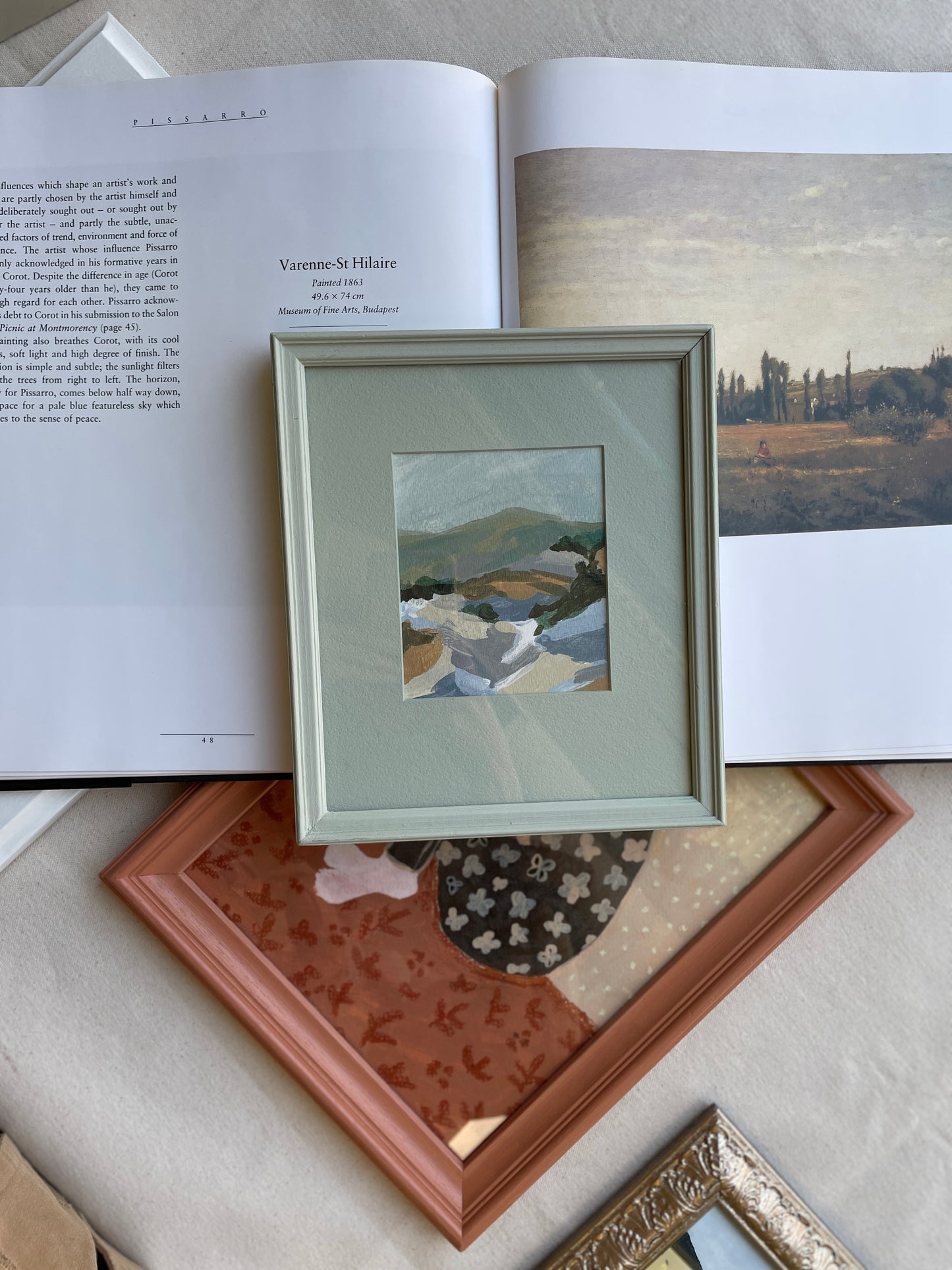 Vintage-framed artwork depicting a serene mountain landscape